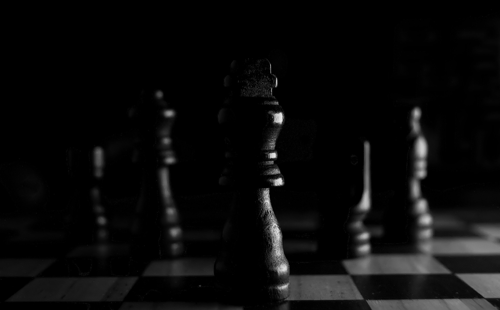 A single chess king lit against a dark board