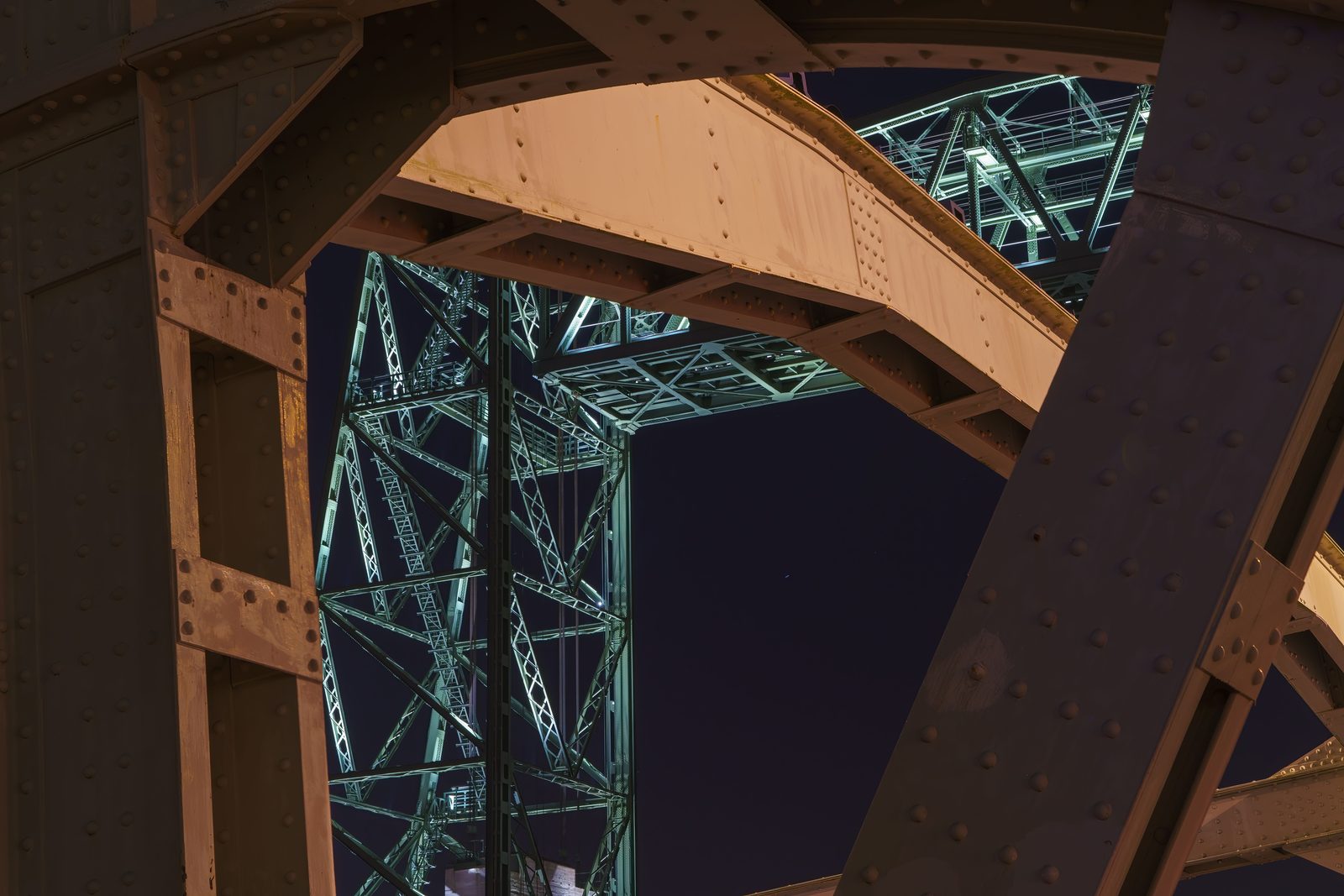 Riveted steel bridge trusses photographed from below at night