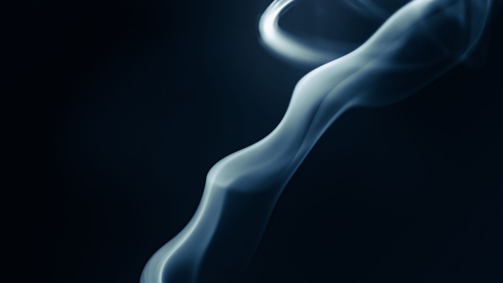 A thin ribbon of vapour curling against a near black background